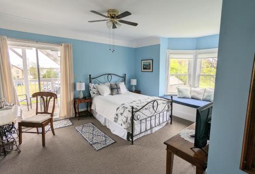 GeorgetownThe Georgetown Inn的一间带蓝色墙壁的卧室和一张带风扇的床