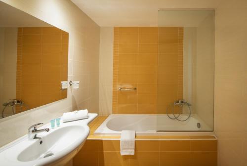 巴利恩Mitsis Bali Paradise Hotel的浴室配有盥洗盆和浴缸。