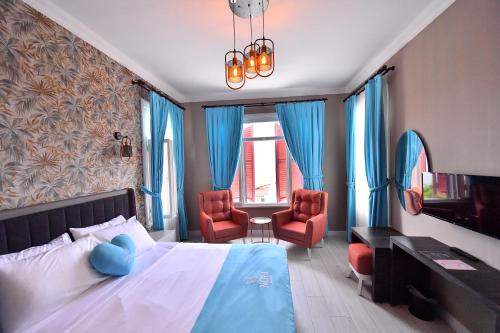 王子岛群Noya Köşk Otel的一间卧室配有一张床和两张红色椅子