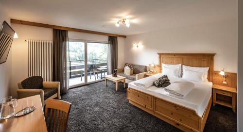 阿尔卑斯休斯山施慕恩酒店的酒店客房设有一张大床和一张书桌。