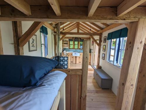 多切斯特Gaggle of Geese Pub - Shepherd Huts & Bell Tents的一间小房子里带床的房间