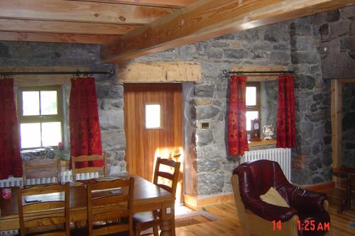 戈尔韦Traditional Stone Cottage 300 years+的一间设有桌子和石墙的用餐室