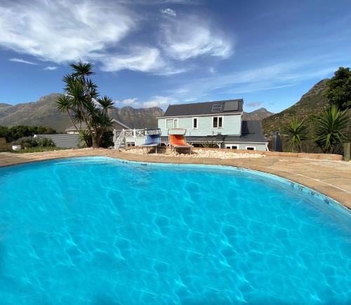 豪特湾Villa Amanzi的一座大蓝色游泳池,位于房子前