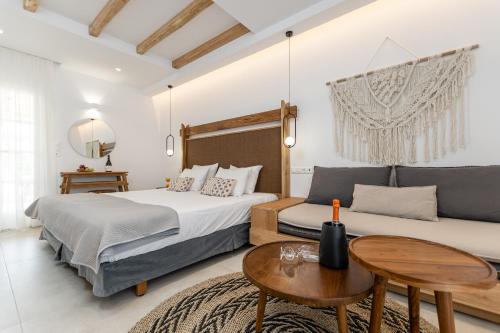 纳克索乔拉斯皮罗斯酒店的一间卧室配有两张床、一张桌子和一张沙发
