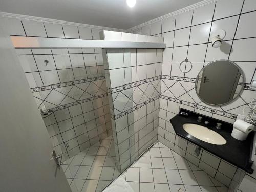 巴西利亚伊科诺酒店的白色瓷砖浴室设有水槽和镜子