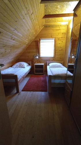 亚伊采Apartman Relax in Nature的小木屋内带两张床的房间
