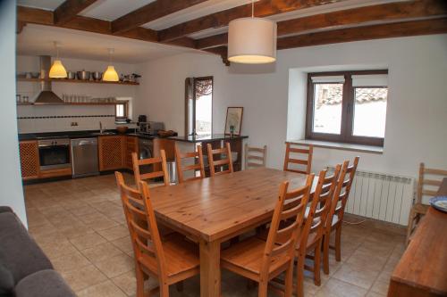 绍塞列vivienda turistica EL PATIO的厨房以及带木桌和椅子的用餐室。