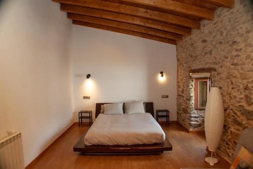 绍塞列vivienda turistica EL PATIO的一间卧室设有一张床和石墙