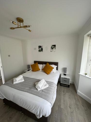 雷利3 bed luxury open plan living的一间卧室配有一张带黄色枕头的大床