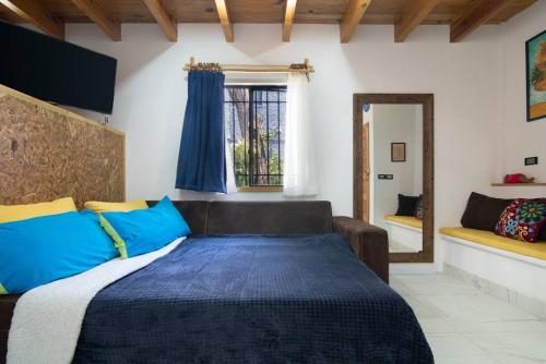 墨西哥城Ursus, Mi casita en México的一间卧室配有蓝色和黄色枕头的床