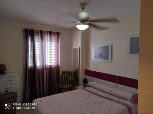 马萨龙港URBANIZACION PUEBLO SALADO BEACH的一间卧室配有一张床和吊扇