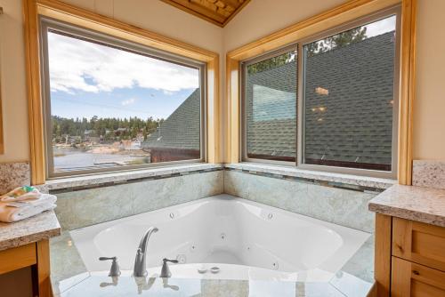 大熊湖Boulder Bay Chalet Lakefront - Elegantly decorated with Hot Tub and Game Room!的带浴缸的浴室和2个窗户