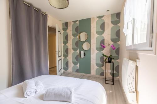沃勒维克Les Lilas Confort & Nature的卧室配有白色的床和绿色白色的墙壁