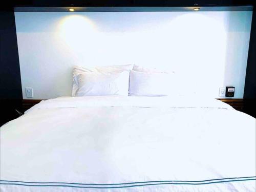 埃斯孔迪多港Villa Ocean的一张带白色床单和枕头的床