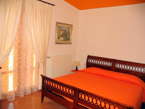 圣马力诺拉卡萨博斯基住宿加早餐旅馆的一间卧室设有一张大型橙色床和一扇窗户。