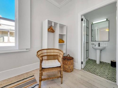 开普敦Exquisite and Homely Apartment, Private Balcony的一个带水槽的浴室内的藤椅