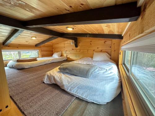 Twin MountainBMV6 Tiny Home village near Bretton Woods的小木屋内一间卧室,配有两张床
