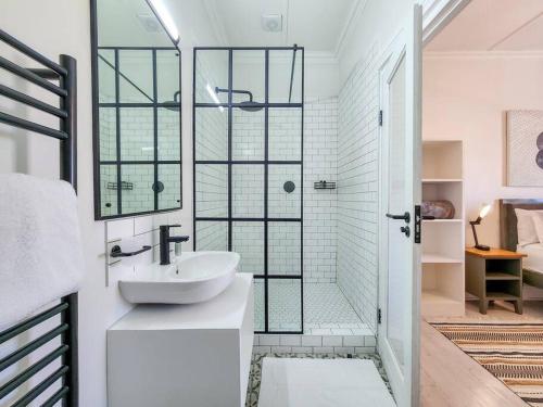 开普敦Contemporary and Stylish Apartment in Observatory的带淋浴和盥洗盆的白色浴室