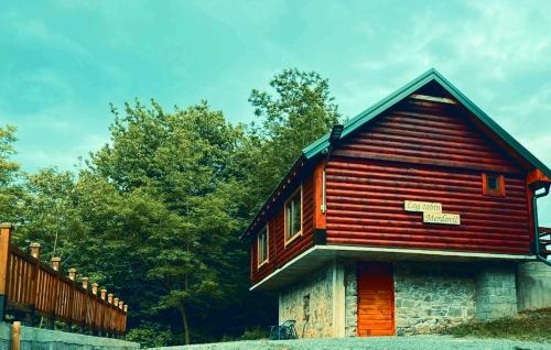 莫伊科瓦茨Log cabin 2 Merdovic的一座带围栏和树木的小木房子