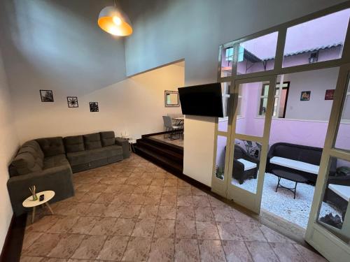 米格尔-佩雷拉Casa Rosada seu refúgio na serra的带沙发和平面电视的客厅