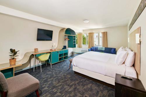 格林波特Greenporter Hotel的配有一张床和一张书桌的酒店客房