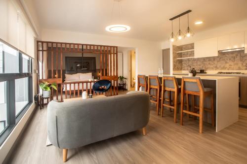 利马Solar by Wynwood House的一间带灰色沙发的客厅和一间厨房