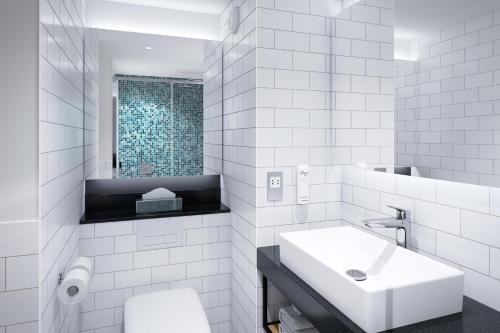 第戎Holiday Inn Dijon Sud - Longvic, an IHG Hotel的白色的浴室设有水槽和镜子