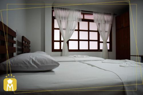 莫科阿HOTEL MONTERREY的一间卧室设有两张床和窗户。