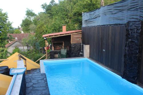维埃拉·多米尼奥Recanto do Sol的一座位于后院的游泳池,有一座黑色的建筑