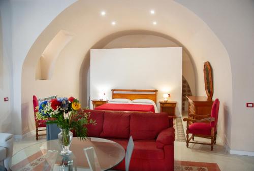 阿格里真托PALAZZO ZUPPARDO LUXURY的一间卧室配有红色的沙发和一张床