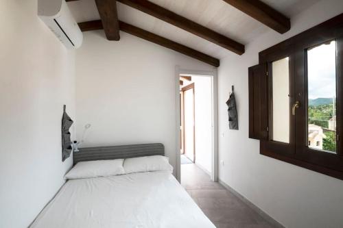 ArmungiaCasa tipica nel borgo antico的白色的卧室设有床和窗户