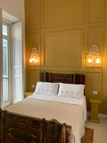 那不勒斯Casa Orlanda的一间卧室配有一张带两个灯的大床