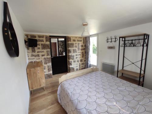 蓬托尔松Aux Berges du Mont的石墙客房的卧室配有床
