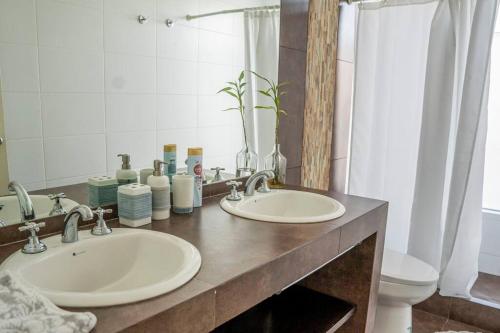 皮斯科Casa de Playa con Piscina Exclusiva的浴室设有2个水槽、卫生间和镜子。