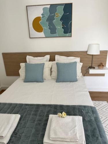 埃武拉HOUSE NEXT TO THE THEATER的一间卧室配有一张带蓝色枕头的大床
