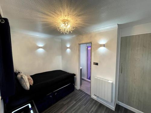 Trimley HeathChic 2 Bedroom Flat的一间卧室配有一张黑色的床和吊灯。