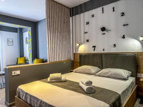 耶拉基尼Comfort Luxury Studio的卧室配有一张挂在墙上的带时钟的床
