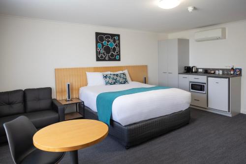 拜恩斯代尔拜恩斯代尔国际酒店的酒店客房配有床、桌子和沙发。