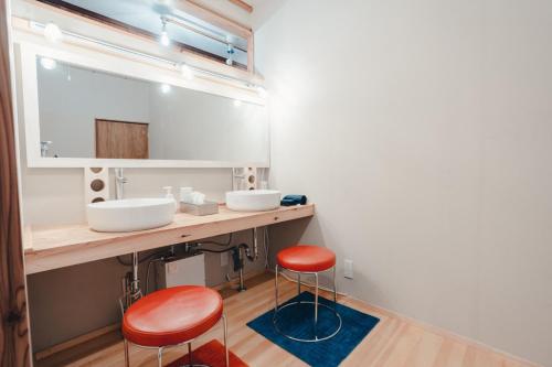 气仙沼市SLOW HOUSE kesennuma - Vacation STAY 31901v的浴室设有2个水槽和2个红色凳子