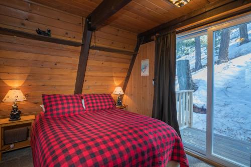 大熊湖Bear Mountain Summit - A-frame nestled in the oaks and pines!的一间卧室配有一张带红 ⁇ 子毯子的床