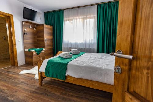 舒加塔格盐矿镇Rustic Maramureș的一间卧室配有床和绿帘
