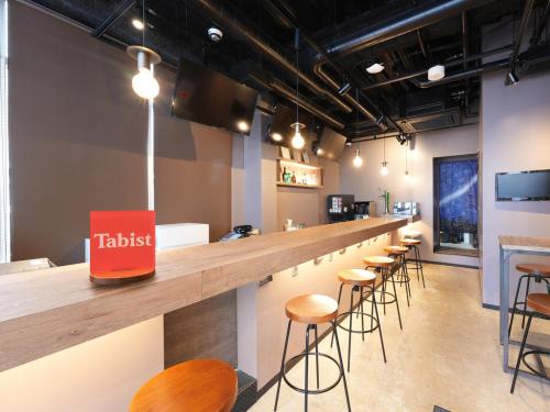 横滨Tabist MAYUDAMA CABIN的餐厅的酒吧,带凳子