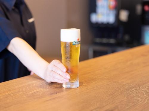 横滨Tabist MAYUDAMA CABIN的一个人在桌上拿着一杯啤酒