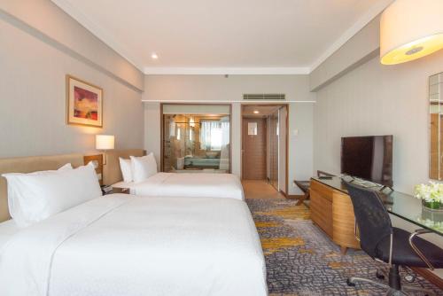 上海上海浦东福朋喜来登由由酒店的酒店客房设有两张床和电视。