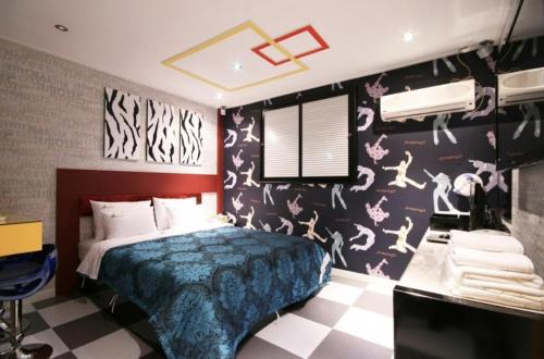 全州市Jeonju Blue One的一间卧室配有床和壁纸覆盖的墙壁