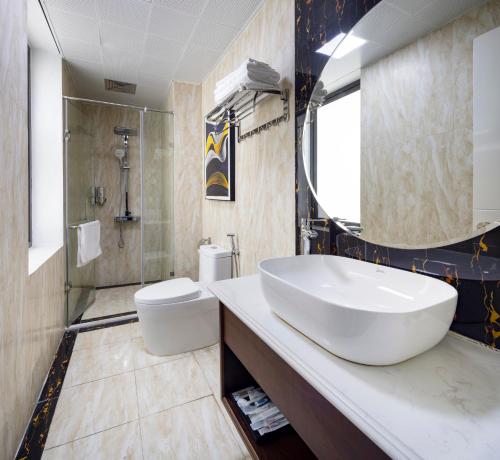 下龙湾Diamond Luxury Hotel的浴室配有大型白色水槽和卫生间