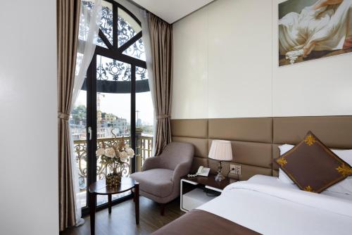 下龙湾Diamond Luxury Hotel的酒店的客房 - 带一张床、椅子和窗户