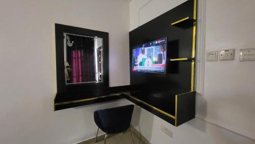 伊凯贾Palazzo Apartments的配有电视、镜子和椅子的房间