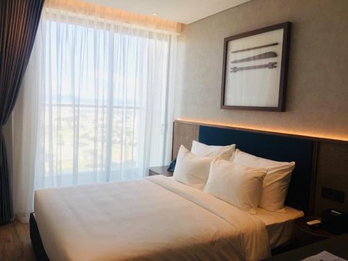 绥和市Toà Nhà Apec Mandala Wyndham Phú Yên的一张位于酒店客房的床铺,设有大窗户