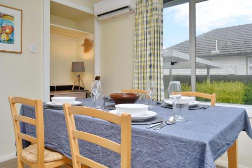 基督城Charlesworth Villa - Christchurch Holiday Homes的餐桌、蓝桌布和椅子